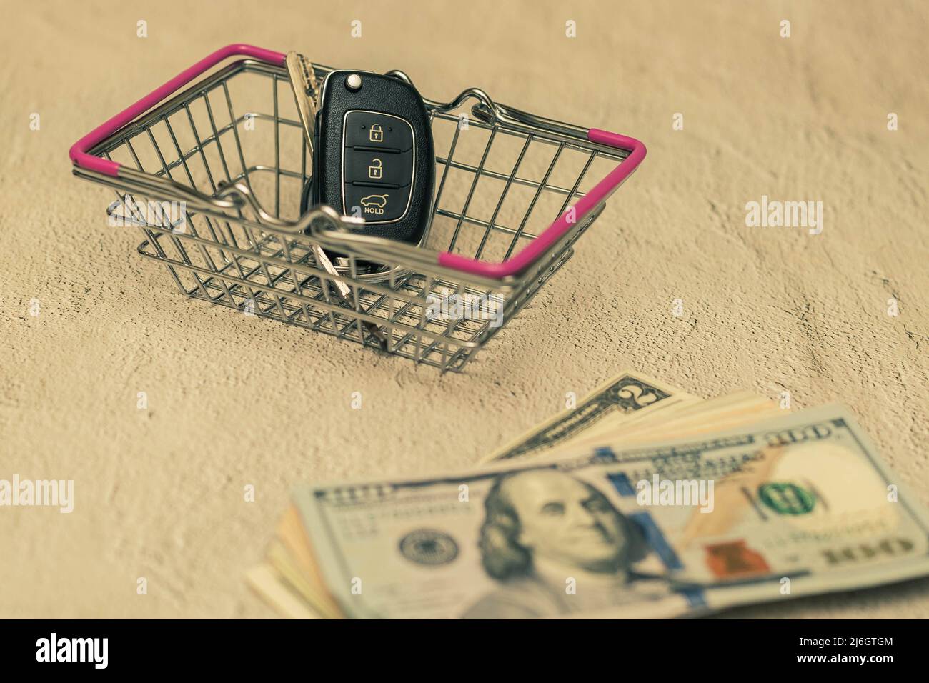 Car keys in a small shopping cart. The concept of buying a car Stock
