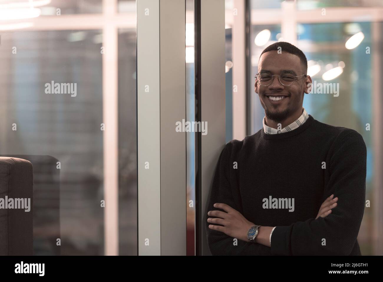 African American man looking at camera standing in office lobby hall. Multicultural company managers team portrait. Stock Photo