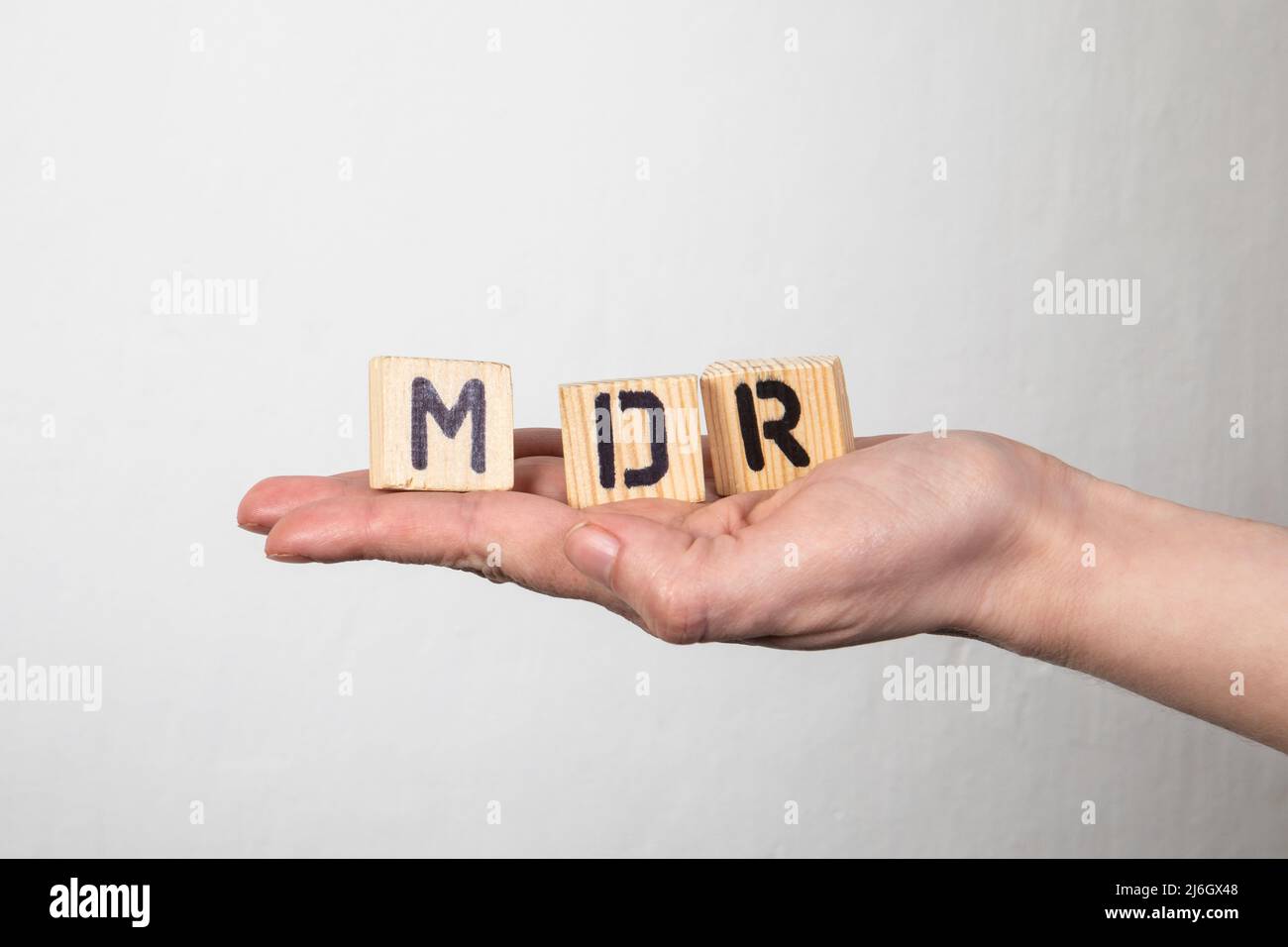 MDR Medical Device Regulation. Wooden letters in a woman's hand. Stock Photo