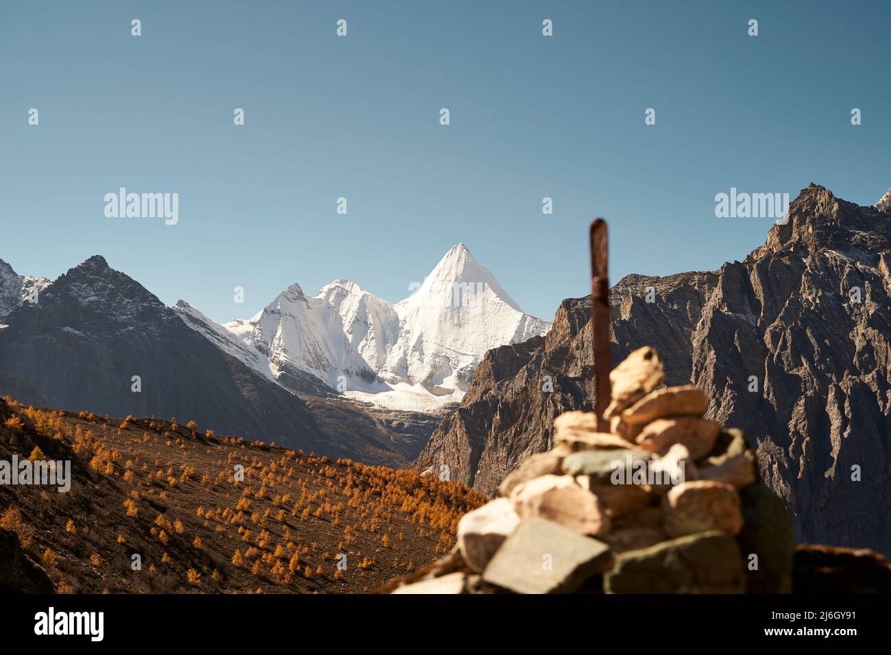 pile of prayer stones (or mani stones) in front of mount jampayang (or yangmaiyong) in yading national park, daocheng county, sichuan province, china, Stock Photo