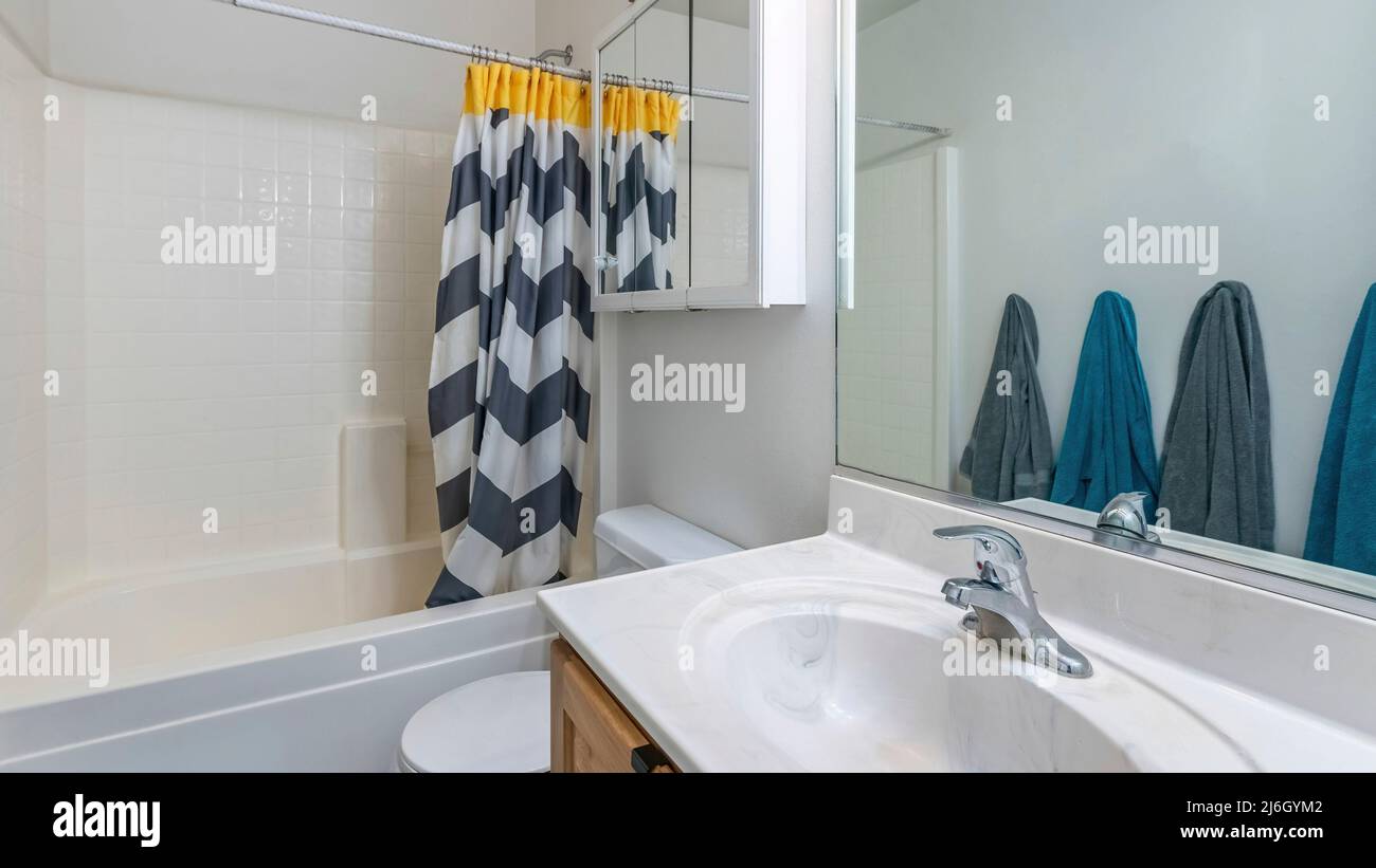 Panorama Interior of a small bathroom with gray and blue towels hanging