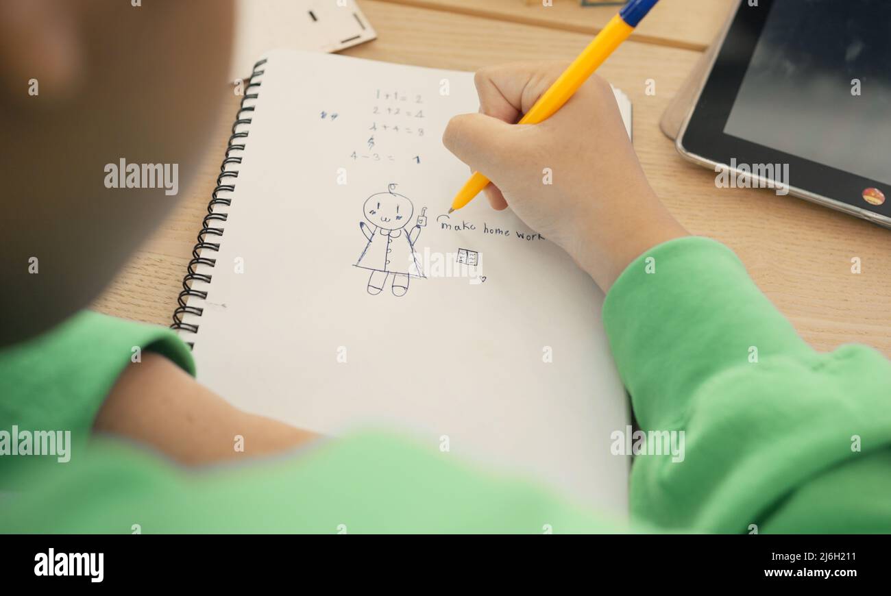 Student in international preschool writing a book together in Elementary School Class, Pupils enjoying studying in classroom. Stock Photo
