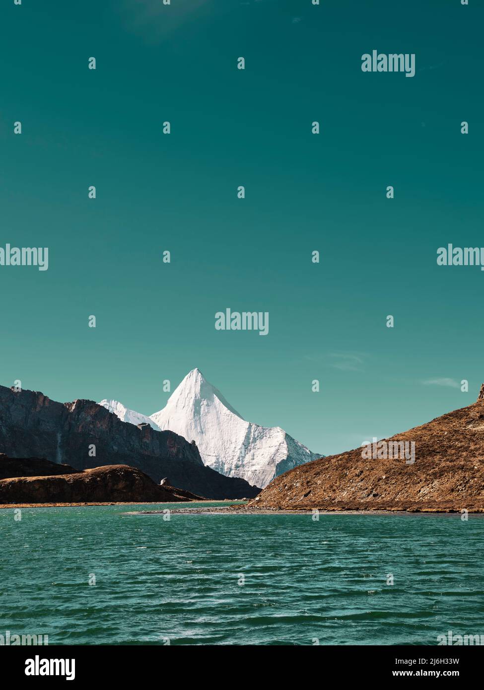 mount yangmaiyong (or jampayang in tibetan language) and lake boyongcuo under the blue sky in yading, daocheng county, sichuan province, china Stock Photo