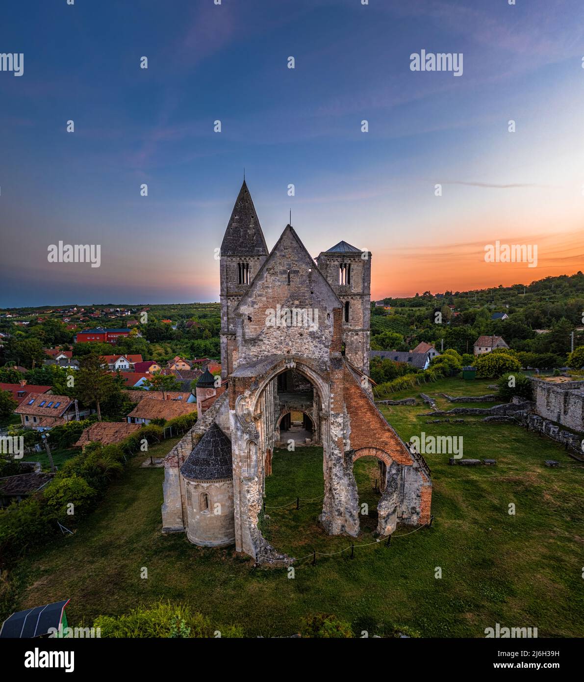 Zsambek, Hungary - Aerial view of the beautiful Premontre Monastery ruin church of Zsambek (Schambeck) with cemetery and colorful dramatic sunset at b Stock Photo