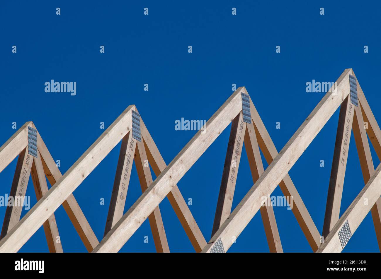 Roof trusses and rafters of a house under construction Stock Photo