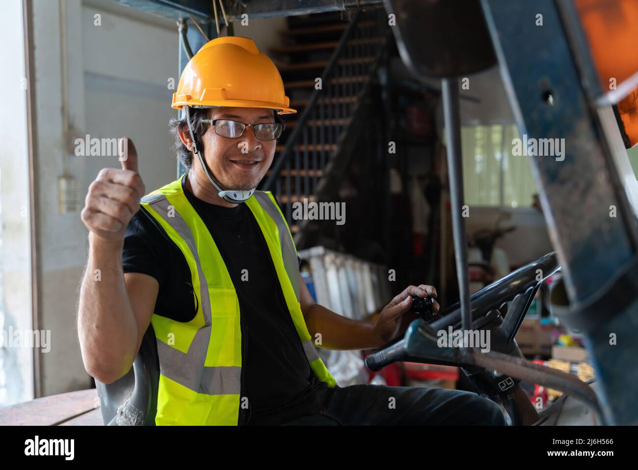 A Worker driving a forklift in warehouse. Stock Photo