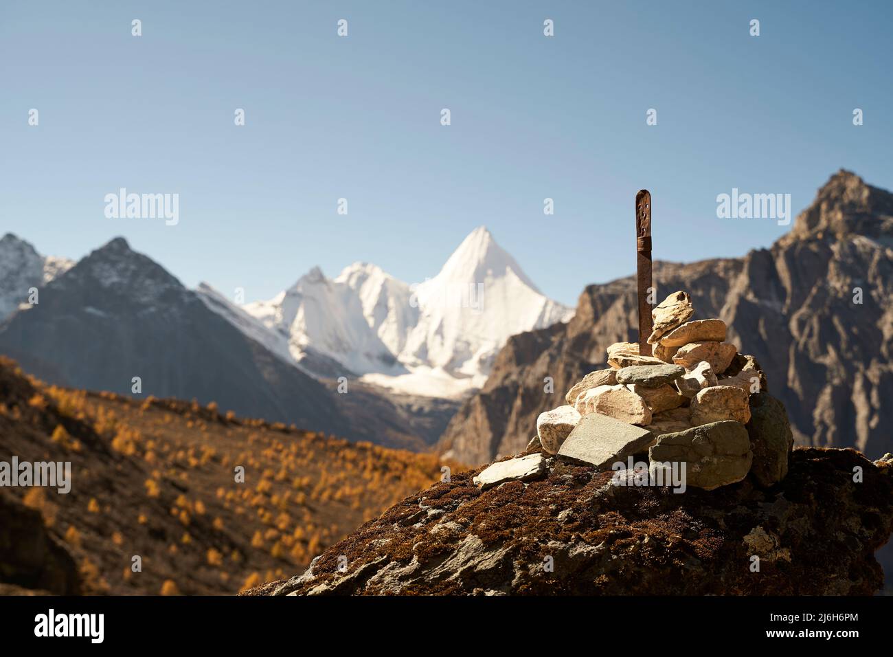 pile of prayer stones (or mani stones) in front of mount jampayang (or yangmaiyong) in yading national park, daocheng county, sichuan province, china, Stock Photo