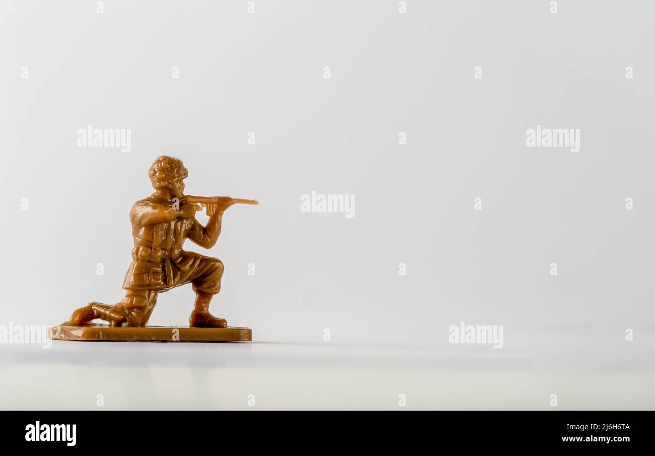 Small plastic toy soldier kneeling down with rifle Stock Photo