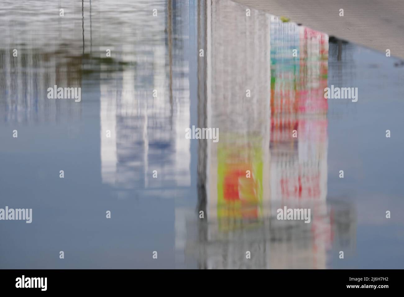 Blurred reflection of buildings in a pool on a city street Stock Photo