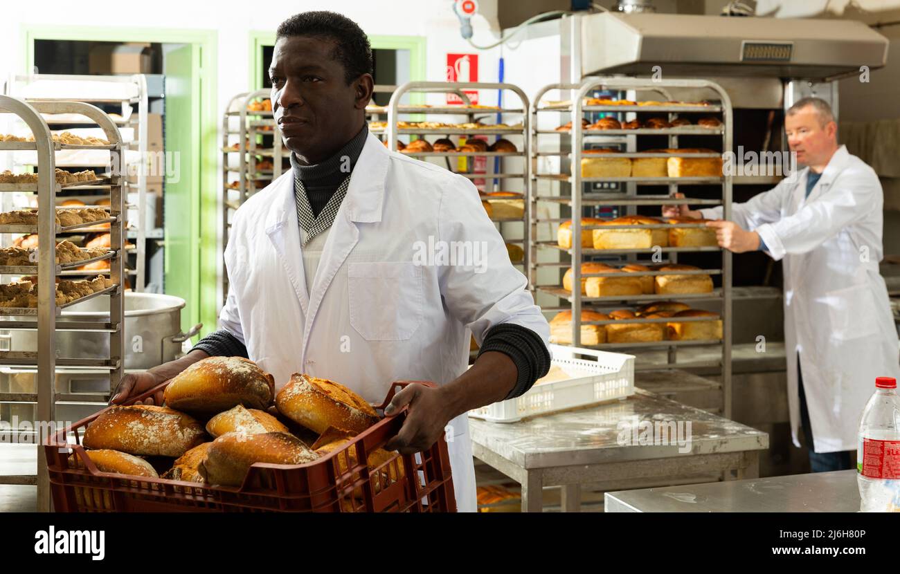 African baker carrying bread in box Stock Photo