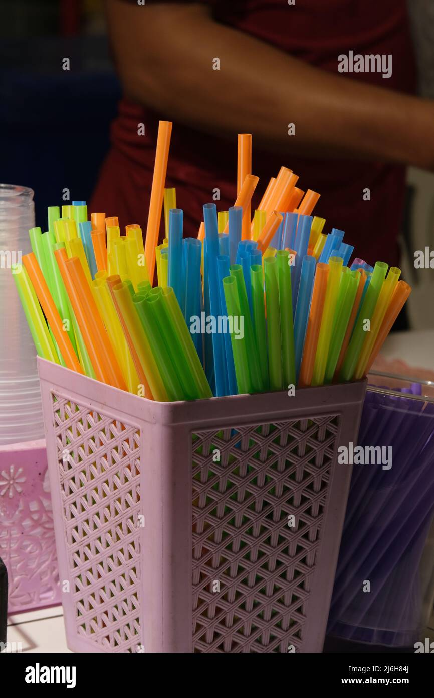 A bunch of colorful plastic straws on a street market stall Stock Photo