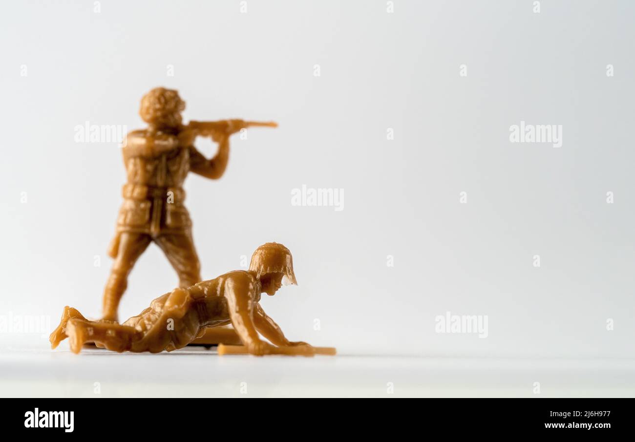 Selected focus crawling comando with out of focus soldier behind  toy soldiers Stock Photo