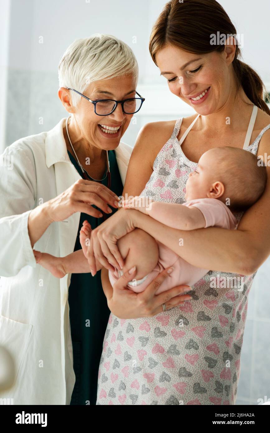 Portrait of happy mother with baby, medical pediatrician doctors, nurse Stock Photo