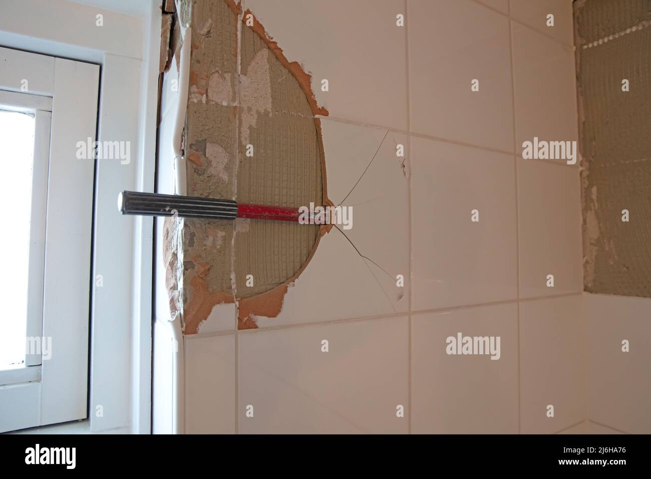 Breaking ceramic tiles, work in progress, maintenance Stock Photo Alamy