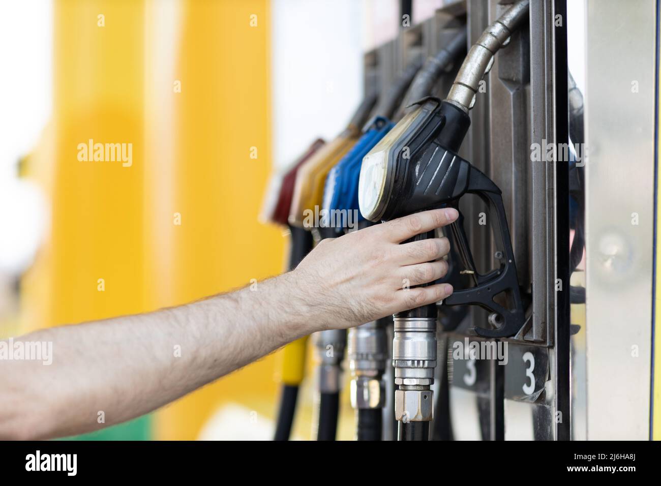 Man holding filling gun in his hand at gas station. Stock Photo