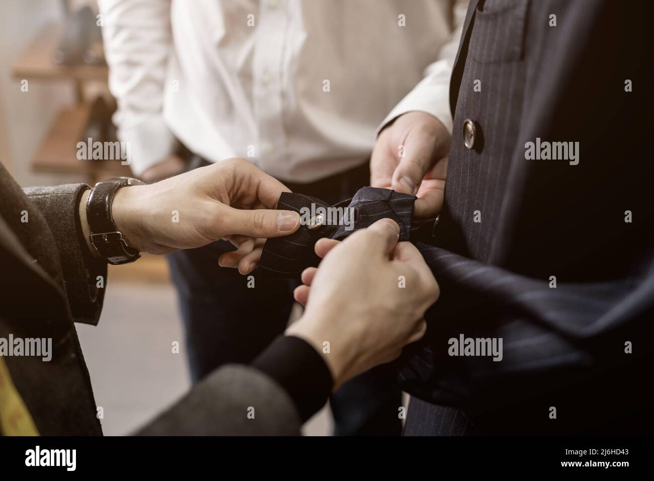 Tailor checking the quality of the suit fabric in a men's clothing