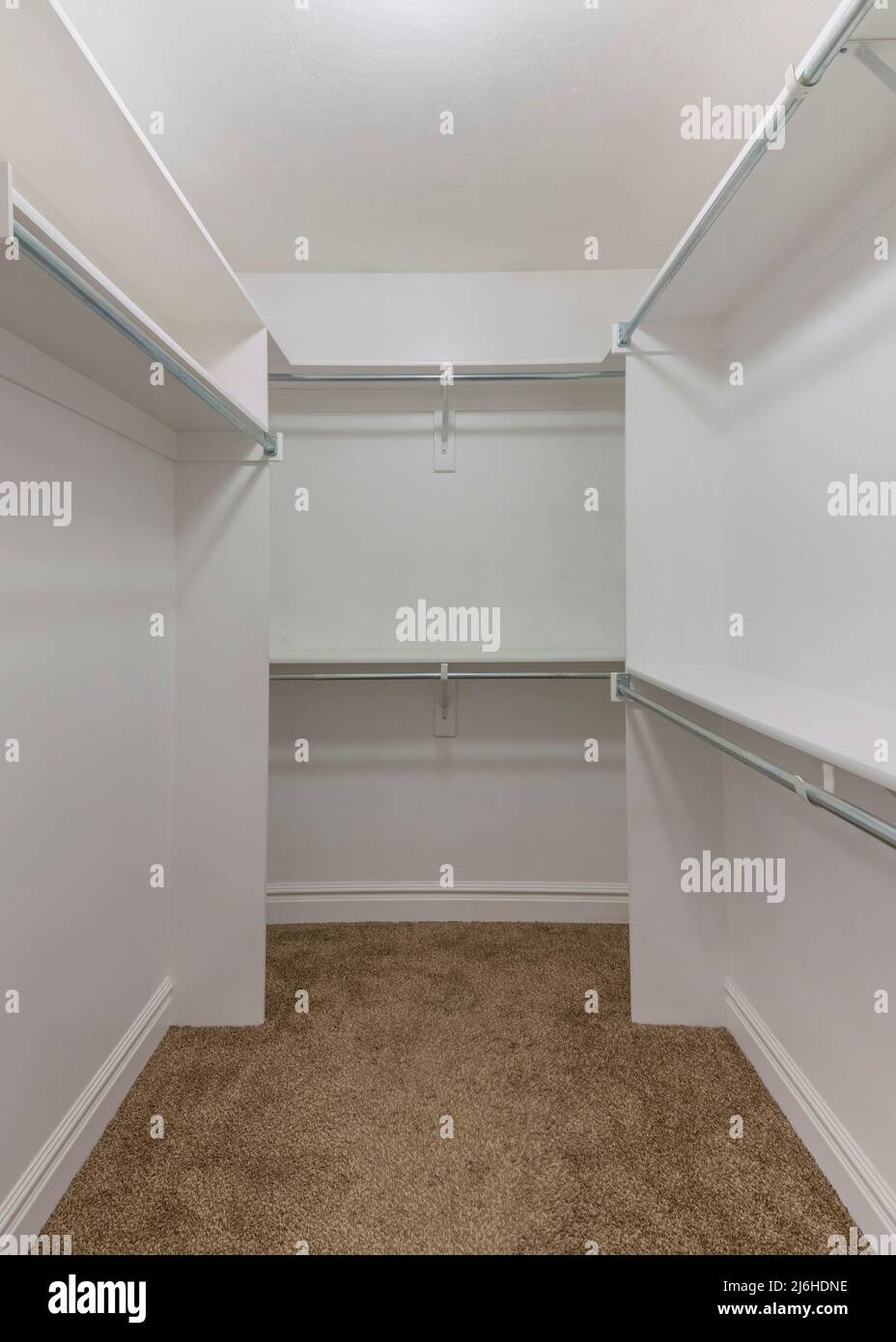 Vertical Empty walkin closet shelving units with metal rods Stock