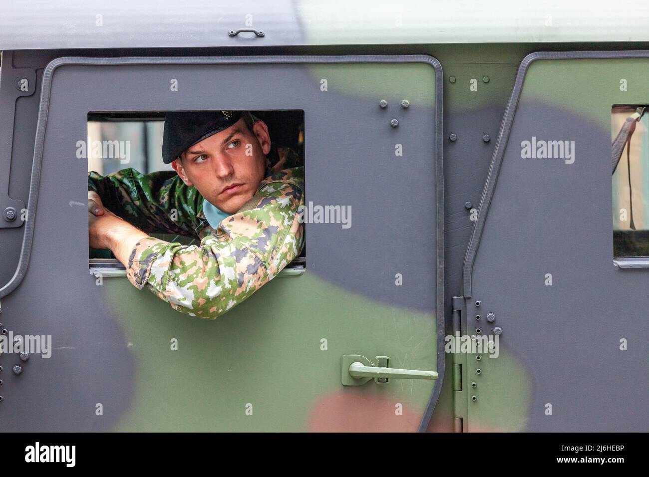 Soldier peeking out of the window of his vehicle. Military parade in ...
