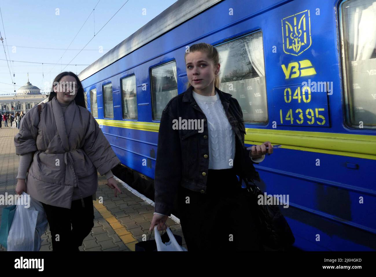 ODESA, UKRAINE - APRIL 25, 2022 - Two women leaving the city due to the Russian invasion carry their belongings along the platform before boarding an Stock Photo