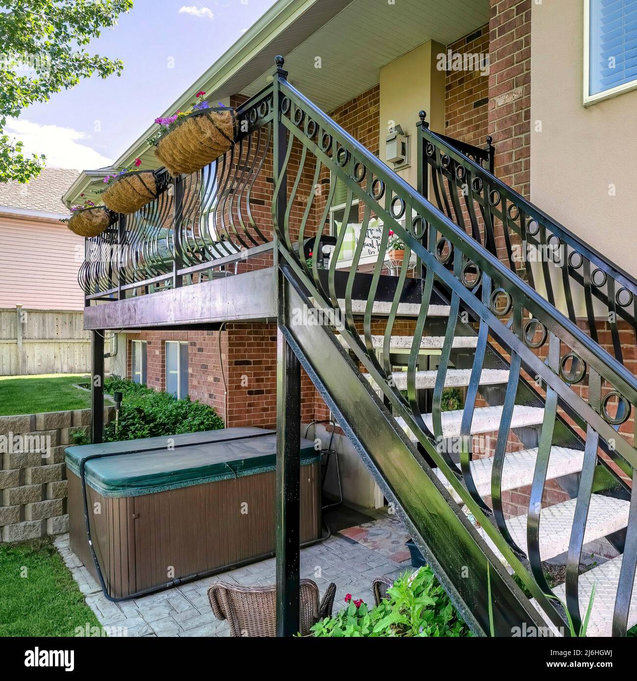 Square Home exterior with red bricks and staircase with metal railings ...