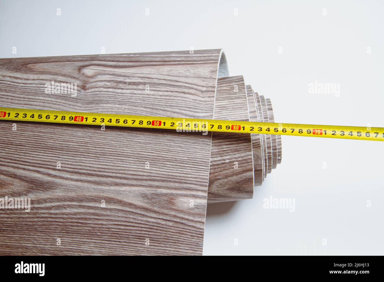 Measurement of linoleum on a cut. Man cuts linoleum. Tape measure and a man's hand with a piece