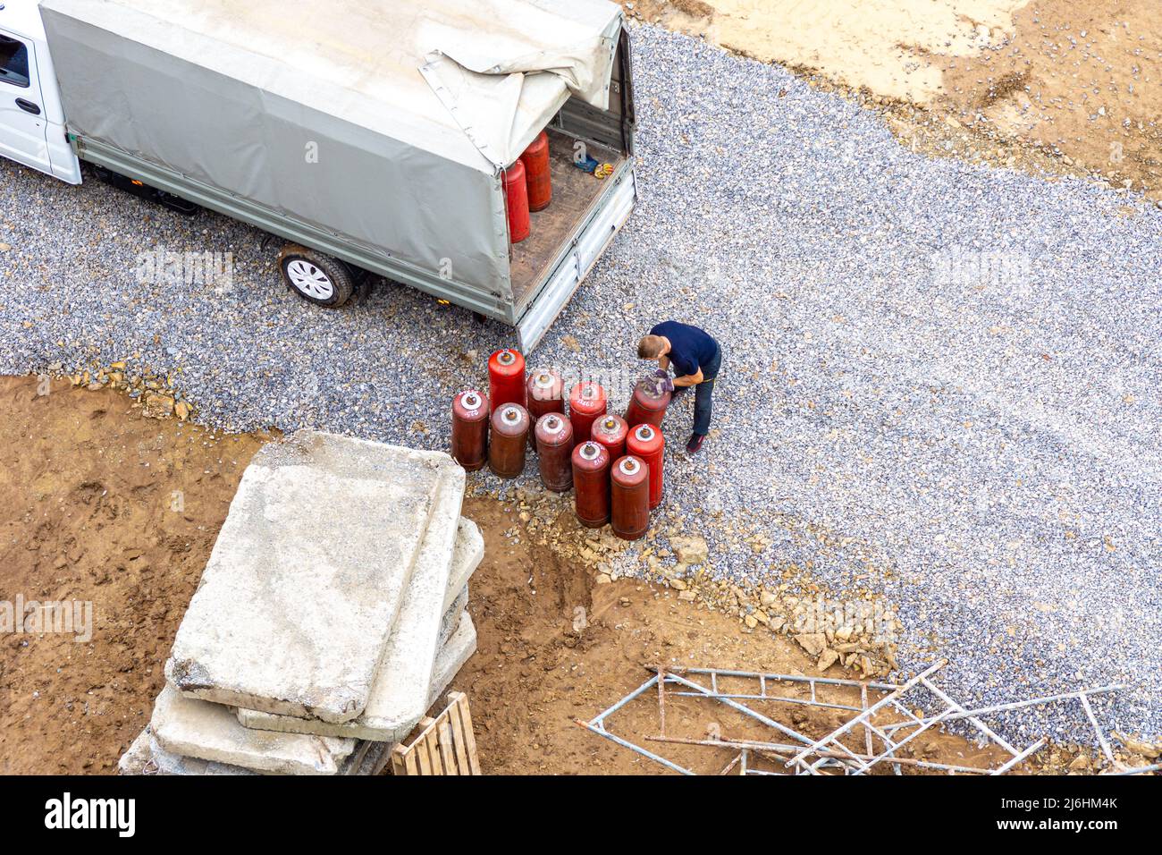 Combustible gas in red cylinders is loaded into a tilt truck to deliver them to the point or the service of filling or exchanging cylinders, selective Stock Photo