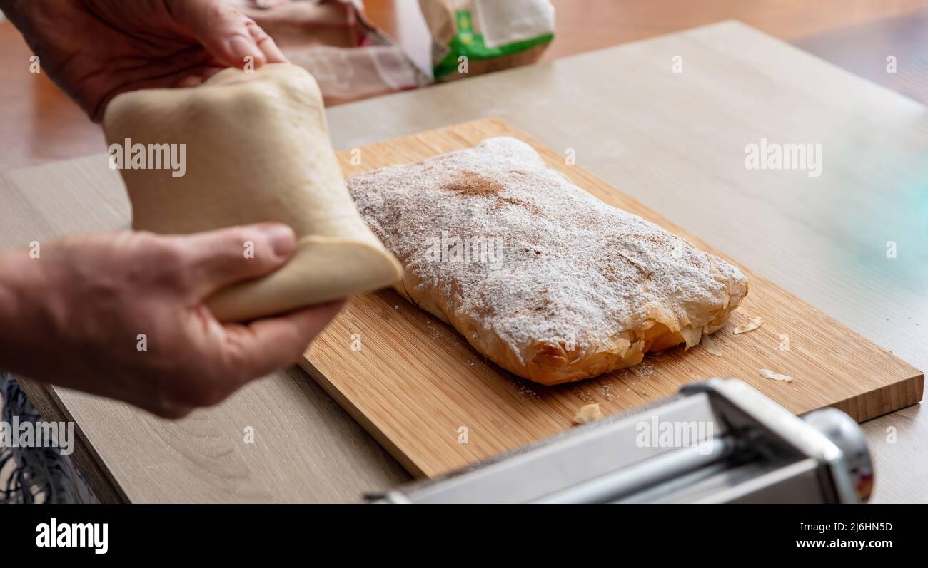 Pasta maker machine. Fresh pasta homemade preparation. Male hand making dough phylo close up view Stock Photo