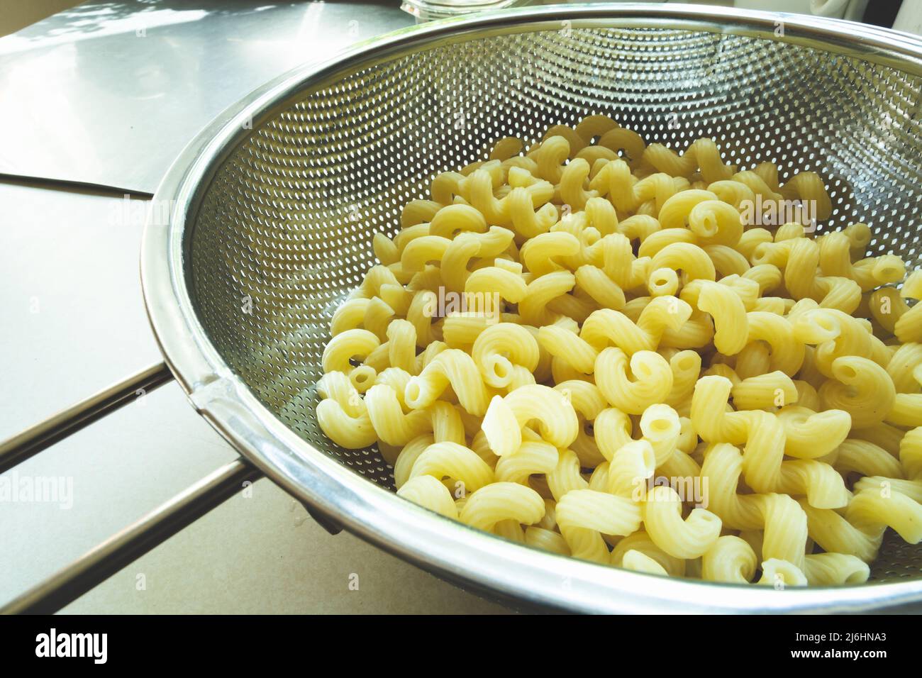 Fresh pasta in a stainless steel silver strainer Stock Photo
