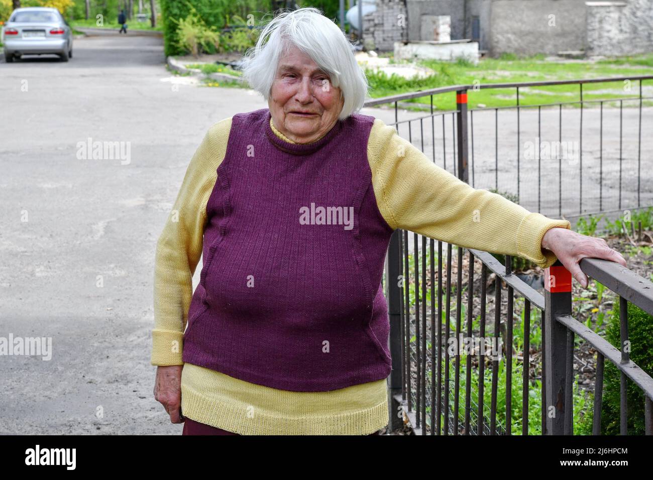 Elizabeth, 88 years old, is crying because of fear to die in the fire  during the shelling while standing by her apartment building that was  damaged by Russian shelling in Sviatohirsk. On