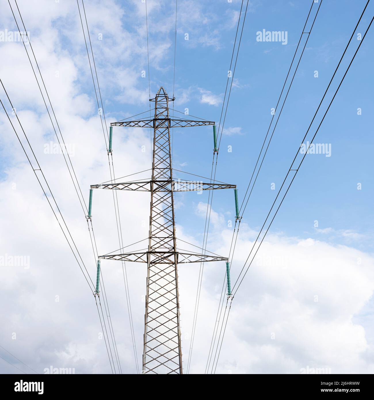 electricity transmission by a high voltage pole and wires aginst a blue sky, Denmark, May 1, 2022 Stock Photo