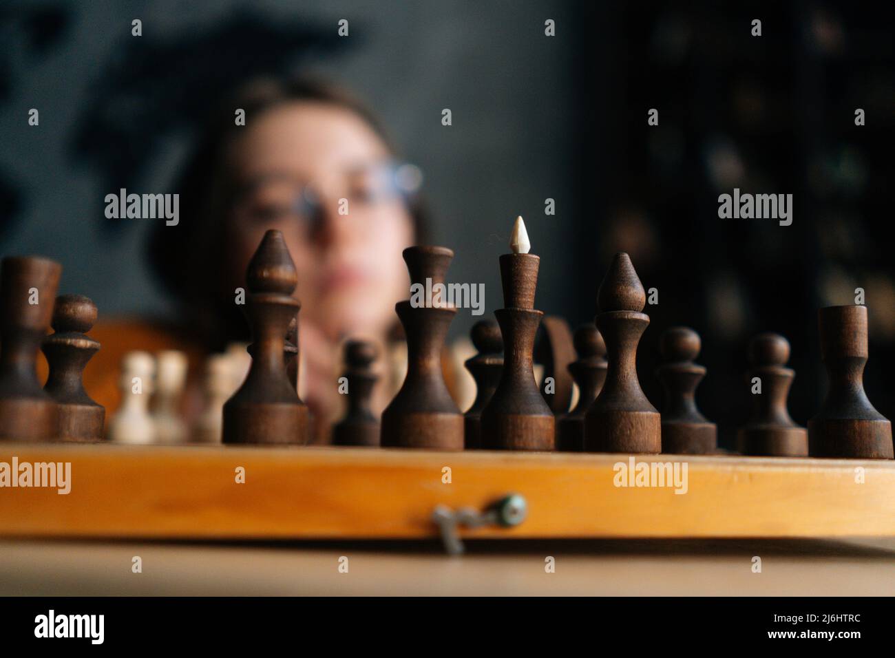 Woman playing chess thinking of next move Stock Photo - Alamy