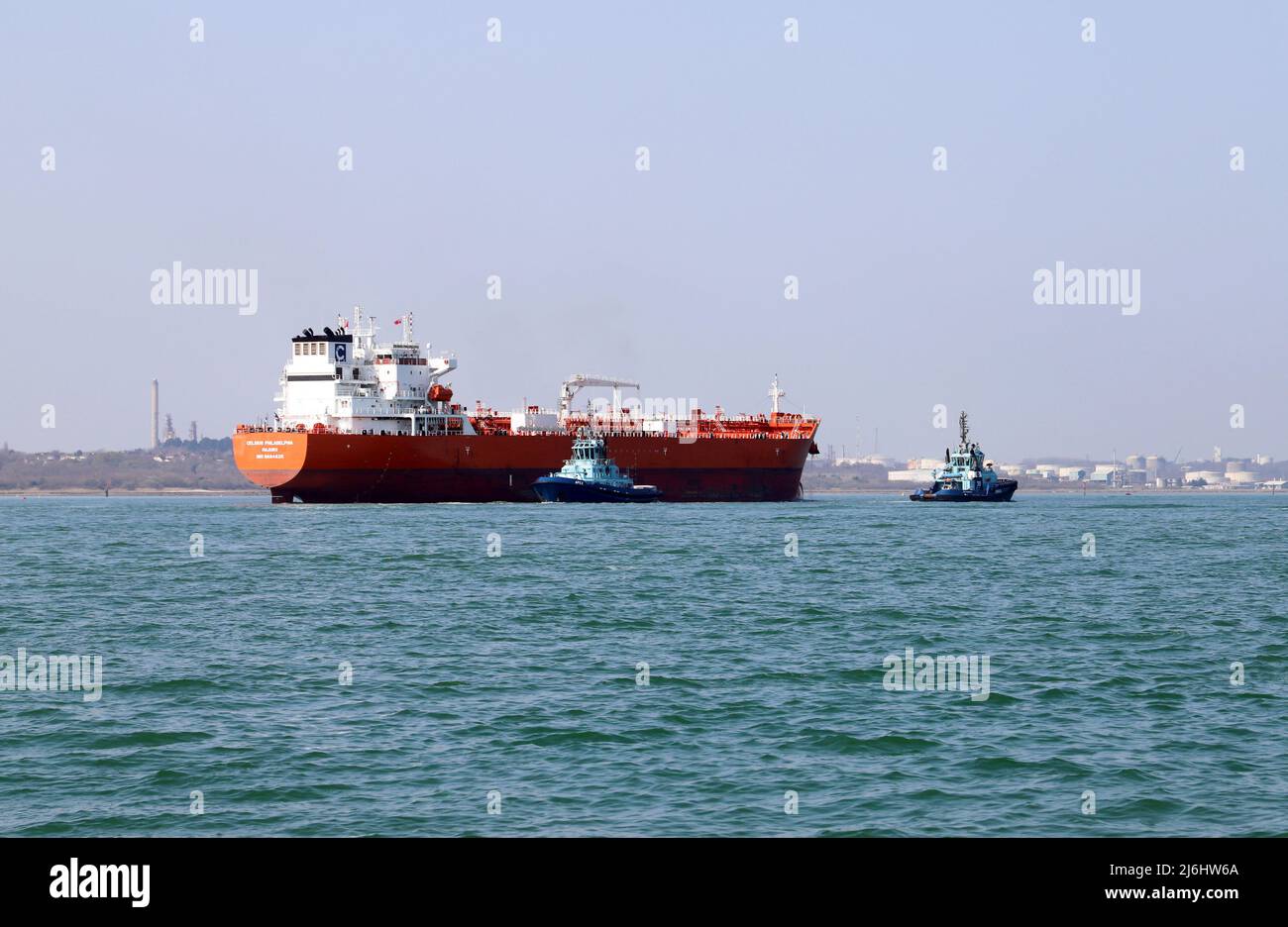 Tugs Apex and Lomax assist the Oil & Chemical Tanker Celcius Philadelphia at Fawley Oil Terminal on Southampton Water Stock Photo