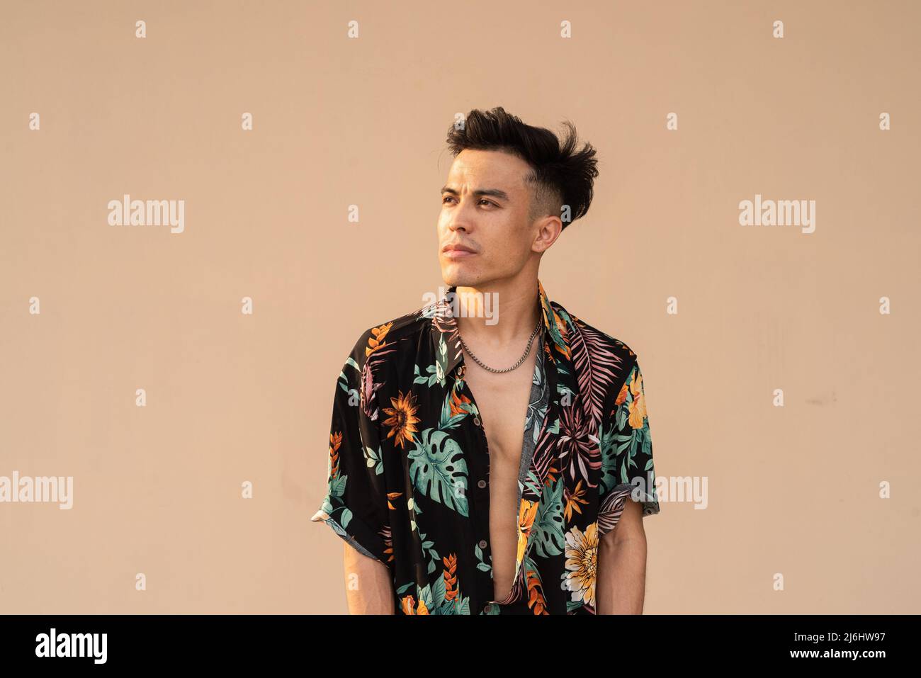 Portrait of handsome young cool stylish man against plain background Stock Photo