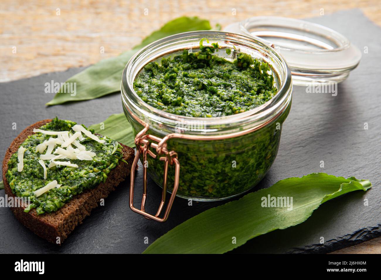 Homemade pesto sauce made with Allium ursinum leaves, known as wild garlic, ramsons, buckrams, broad-leaved garlic, wood garlic, bear leek. Stock Photo