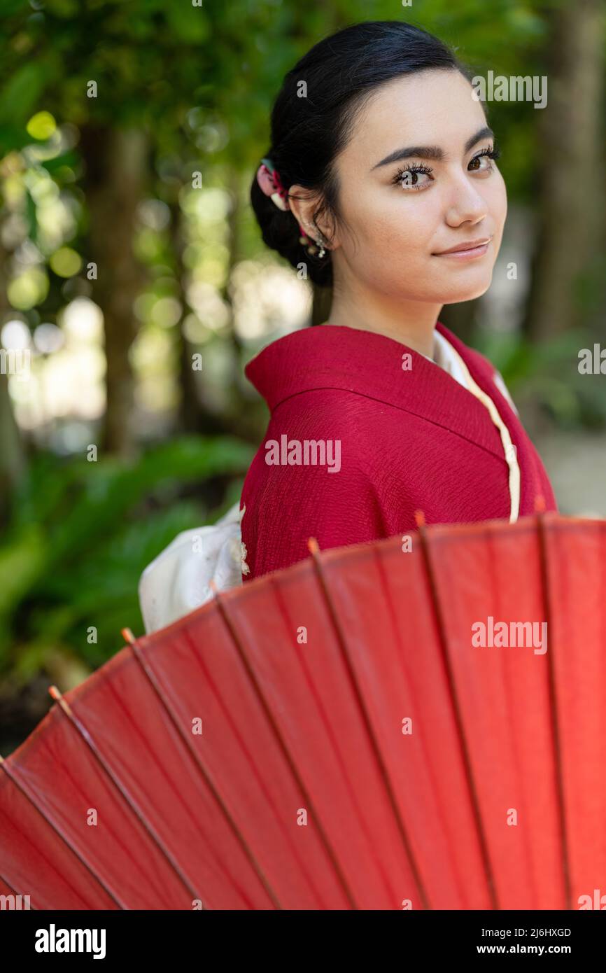 Young woman wearing kimono in the fukugi tree lanes of Bise Village