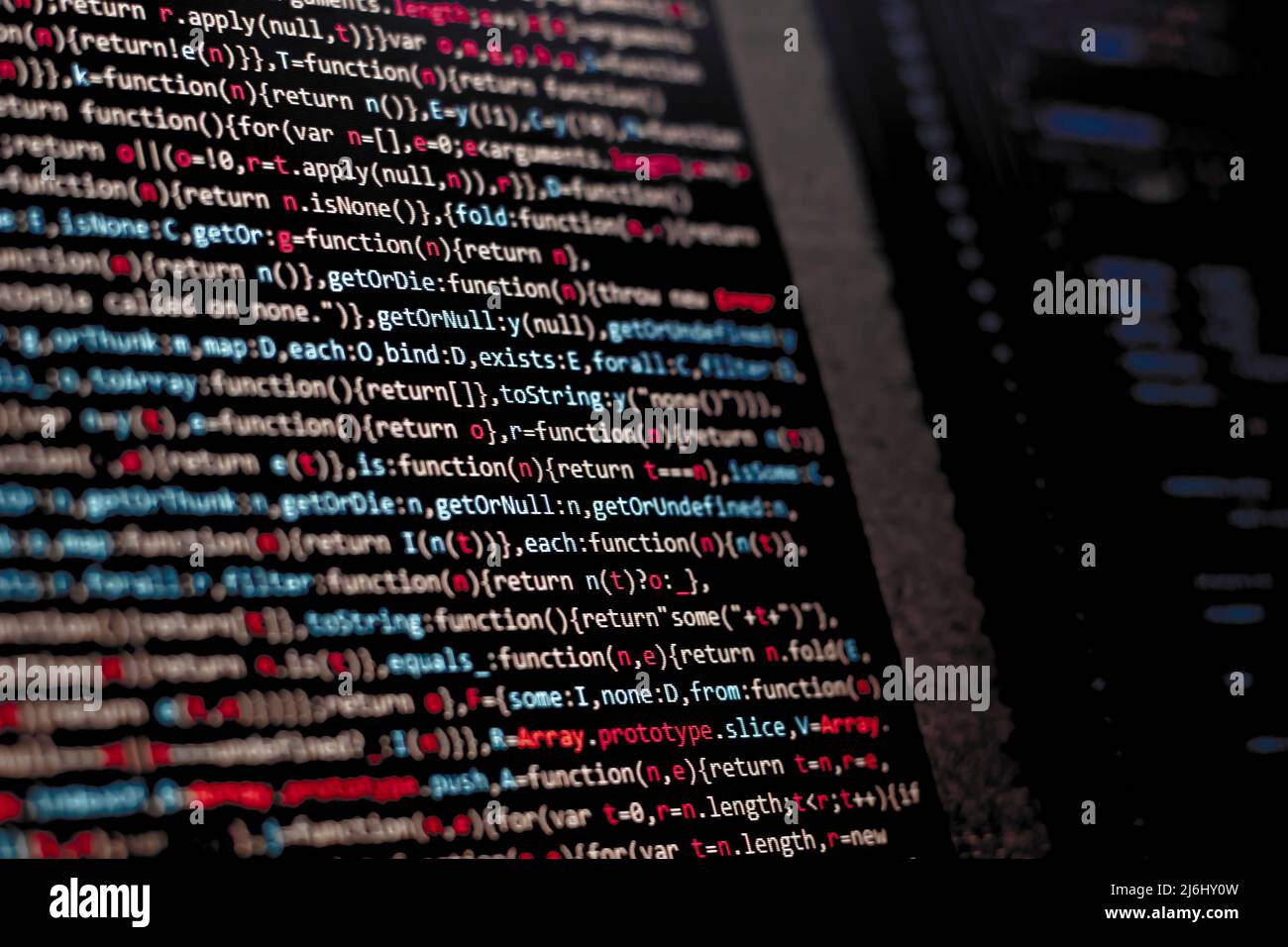 code writing on the office computer screen. red letters intense. web sources creative solutions for digital world. side view of monitor. Stock Photo