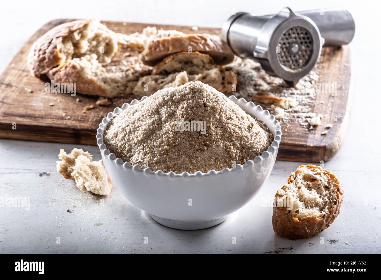 A white bowl full of breadcrumbs and old dry bread around Stock Photo
