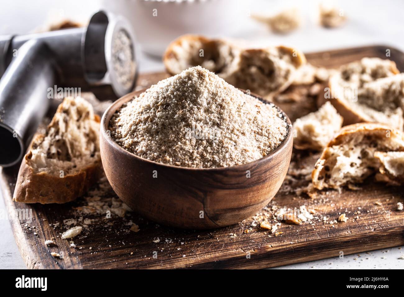 A wooden bowl full of breadcrumbs and old dry bread around Stock Photo