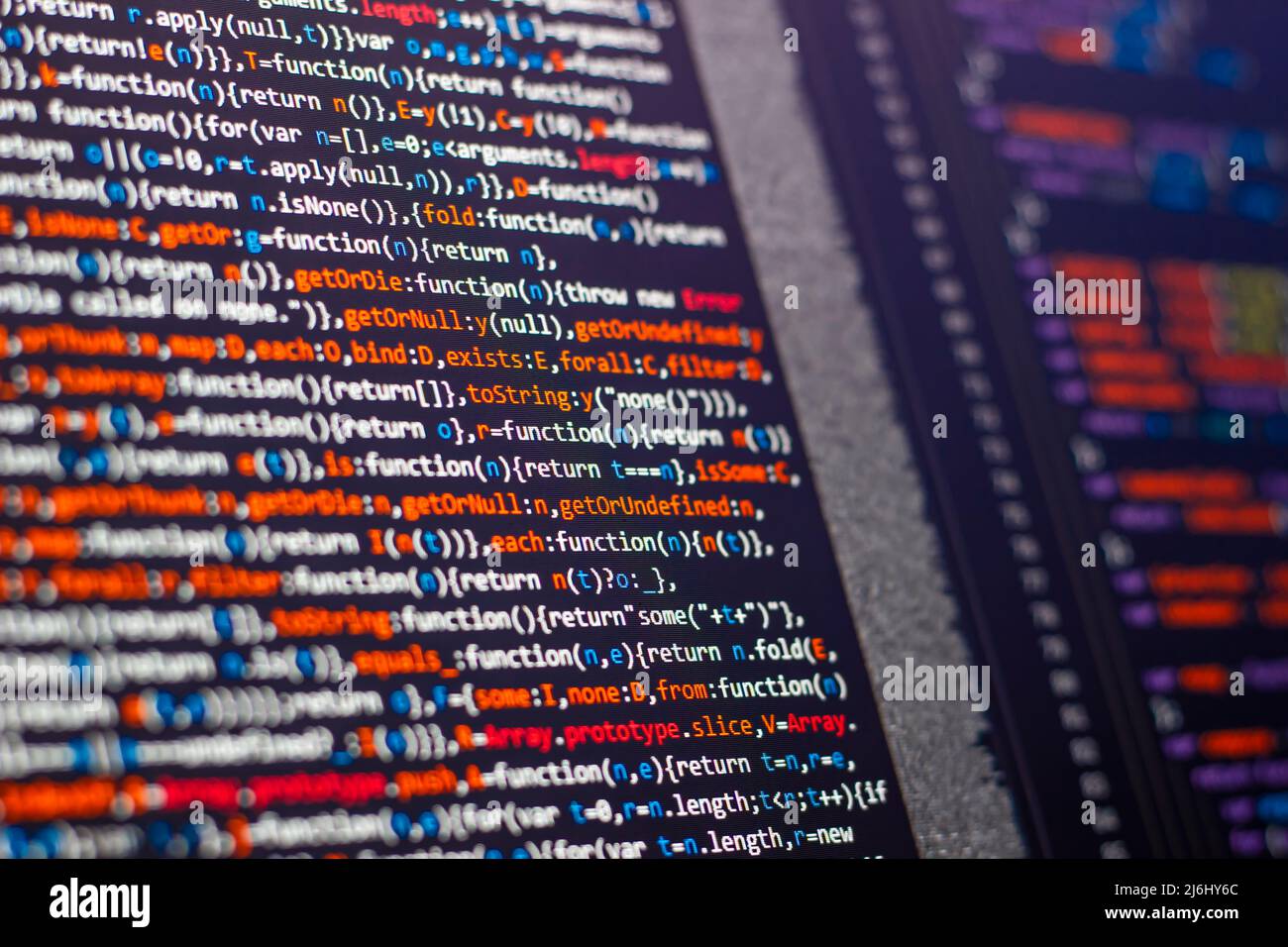 code writing on the office computer screen. red letters intense. web sources creative solutions for digital world. side view of monitor. Stock Photo