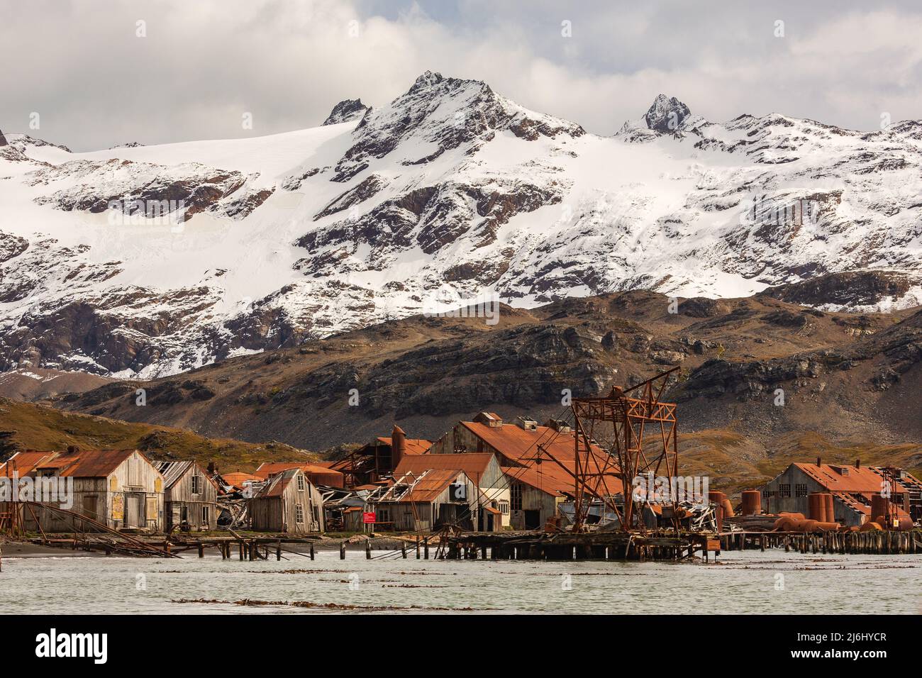 the ruined buildings of the abandoned whaling station of stromness south georgia and snowy mountains Stock Photo