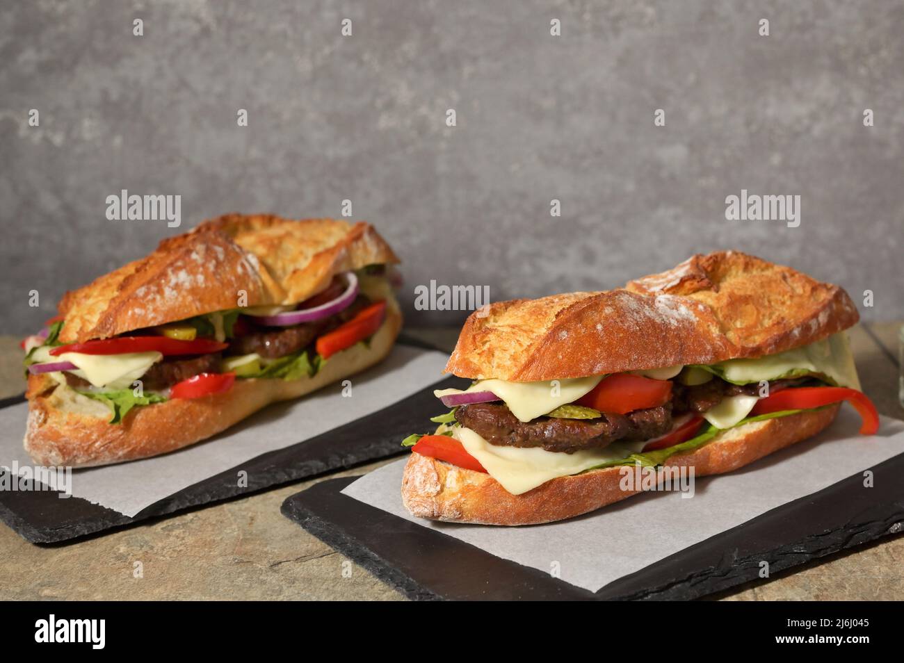 Homemade Burger with Baguette Bread on the wooden table Stock Photo