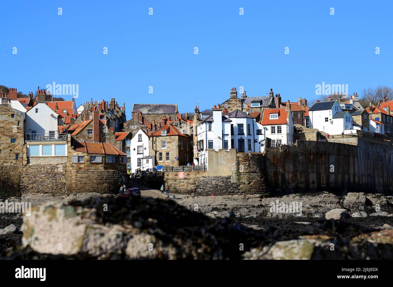 View back to the jumble of rooftops in the quaint village of Robin Hood's Bay, North Yorkshire, from the coastal rock pools Stock Photo