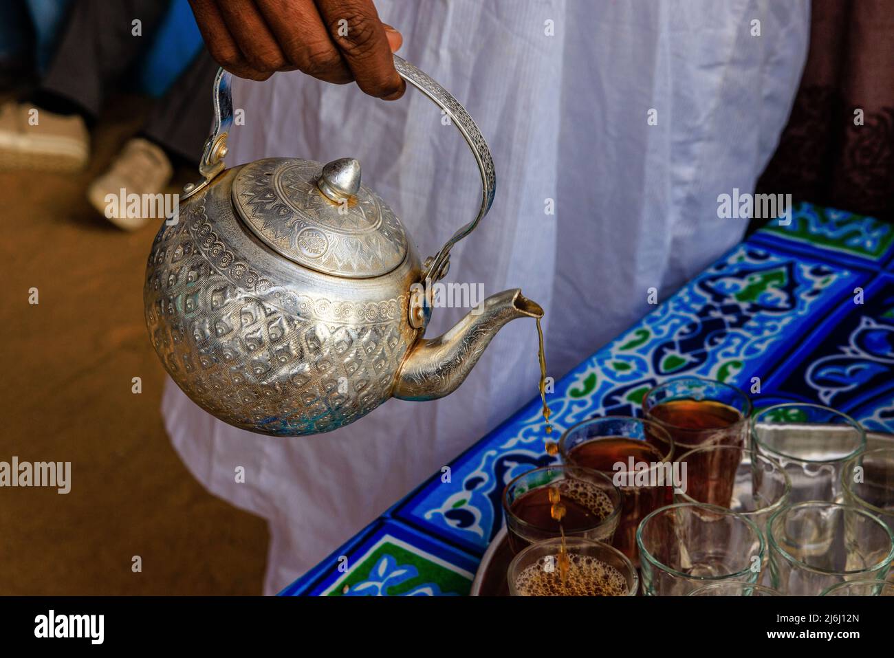 visiting a nubian village in aswan, egypt our host pours tea from a silver teapot Stock Photo