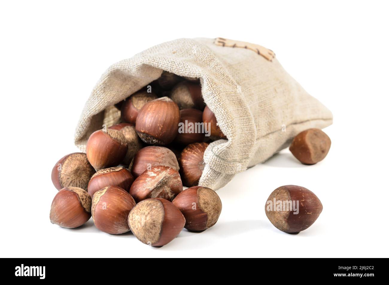 hazelnuts in a woven bag on a white background with soft shadow Stock Photo