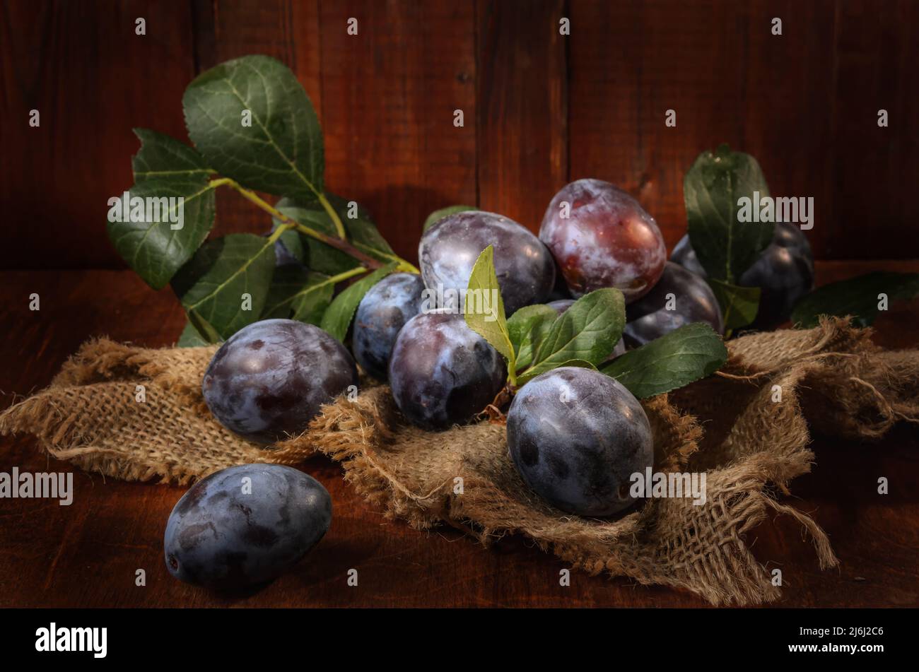 plum in bulk on a dark wooden background in a rustic style Stock Photo