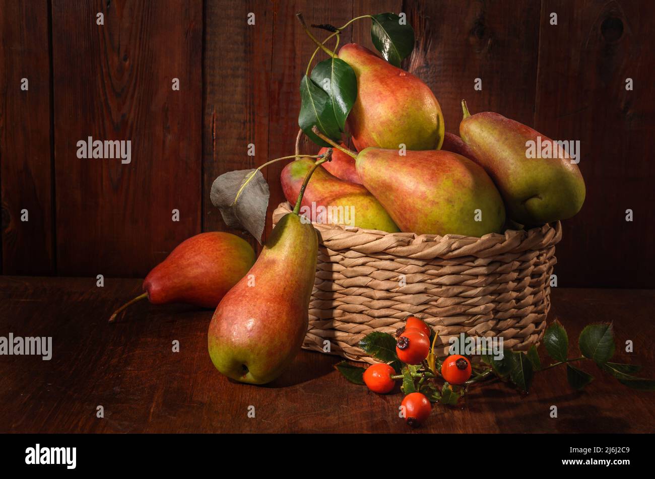 ripe pears in a basket on a dark wooden background in a rustic style Stock Photo