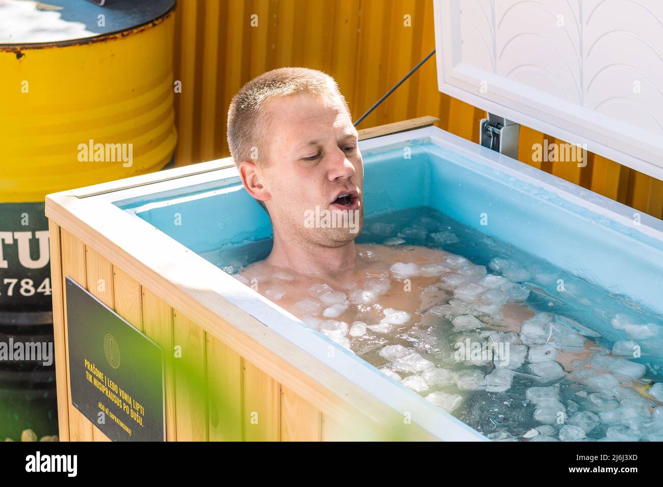 Boy or man breathing deeply and bathing in the cold water among ice