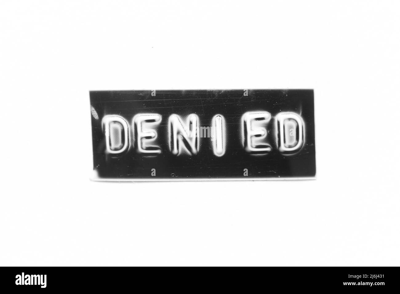 Black color banner that have embossed letter with word denied on white paper background Stock Photo