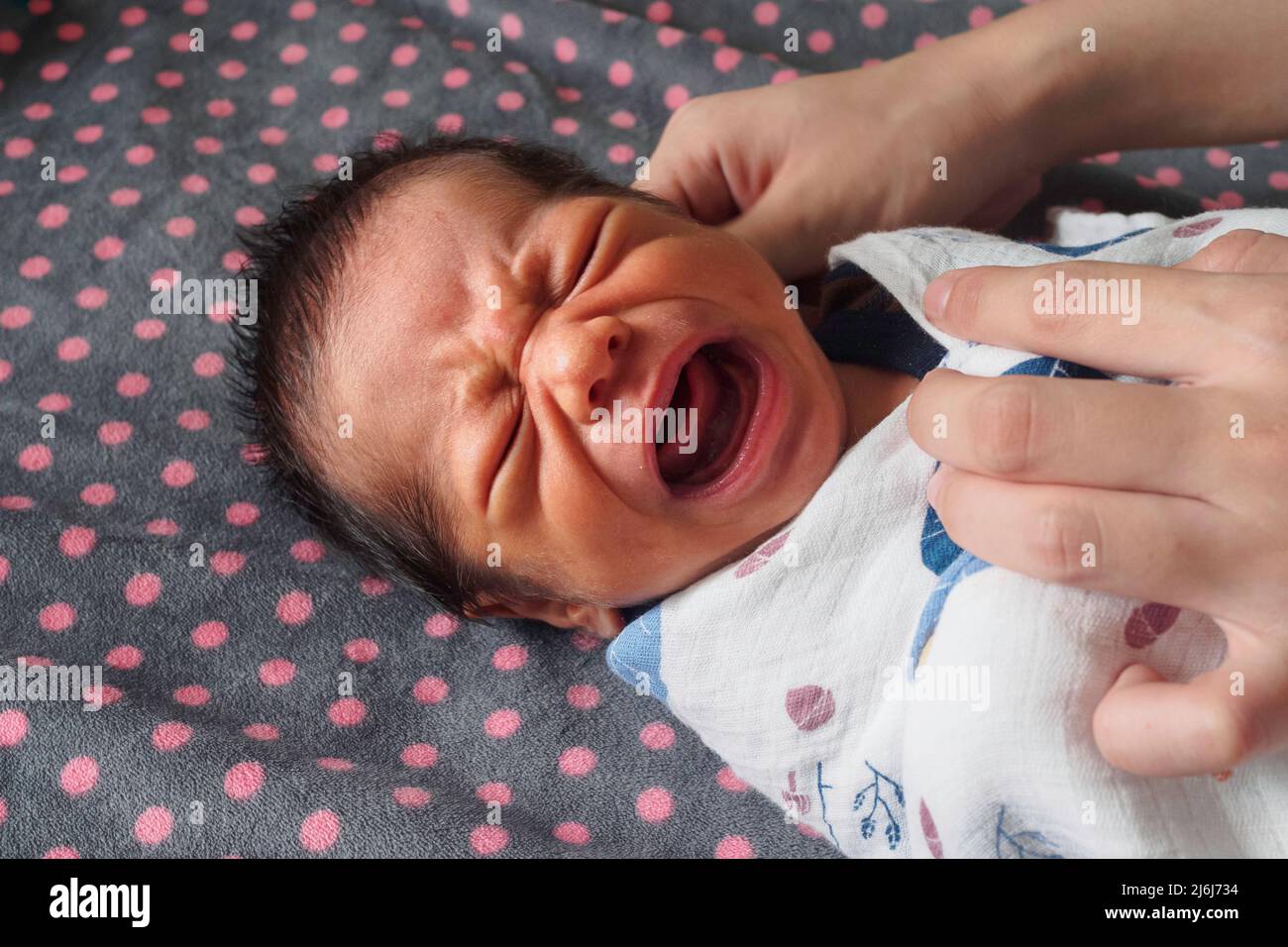 newborn baby boy crying after bathing at children's bedroom in the morning. family, love and life concept. Stock Photo