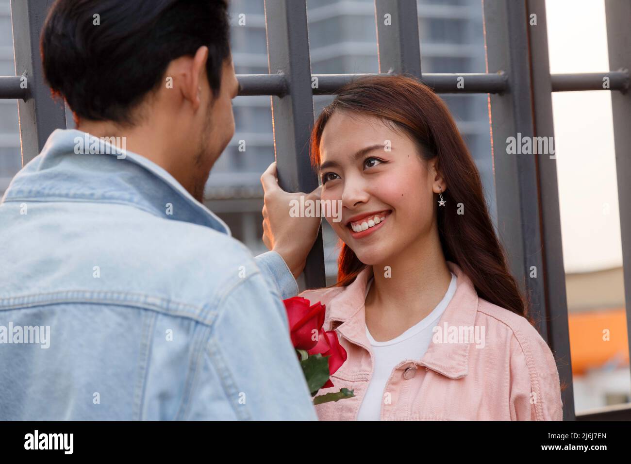 young happy couple love and romantic at first date relationship. asian teenage woman surprise and smiling at boyfriend gives red rose flowers at dinne Stock Photo